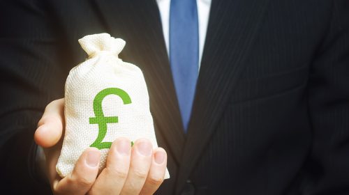 Man in suit holding a back of money