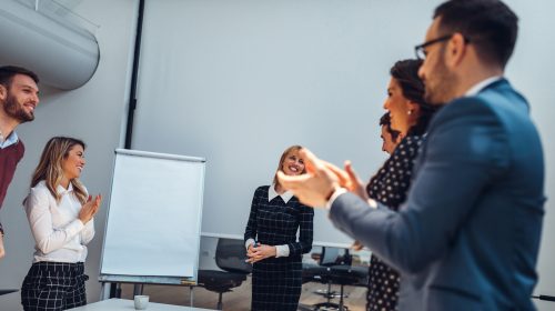 Group of employees saying well done to each other