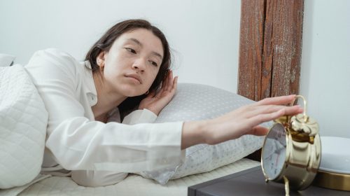 Woman in bed disabling the alarm